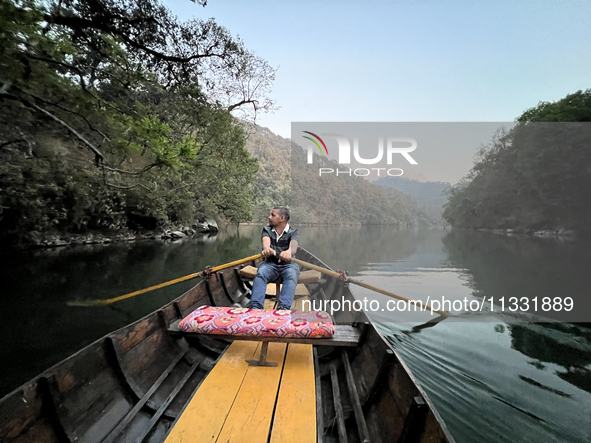 A boatman is rowing a boat along Sattal Lake in Sattal (Sat Tal), Uttarakhand, India, on April 20, 2024. 