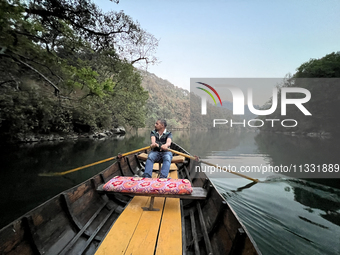 A boatman is rowing a boat along Sattal Lake in Sattal (Sat Tal), Uttarakhand, India, on April 20, 2024. (