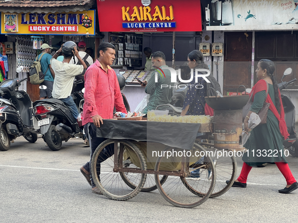 A man is pushing a cart along in the East Fort area as he sells roasted peanuts and popcorn in Thiruvananthapuram (Trivandrum), Kerala, Indi...