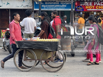 A man is pushing a cart along in the East Fort area as he sells roasted peanuts and popcorn in Thiruvananthapuram (Trivandrum), Kerala, Indi...