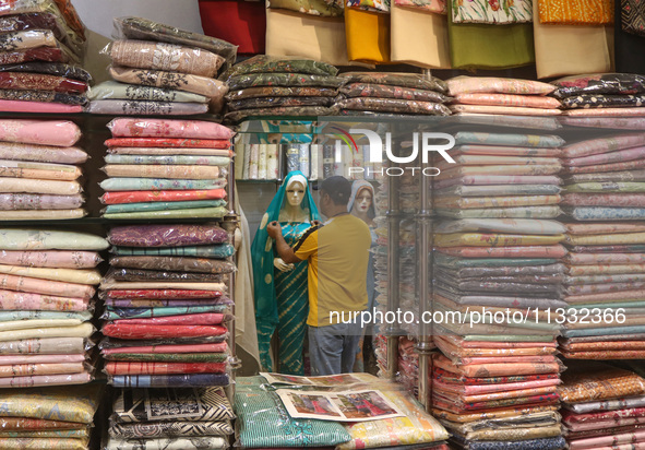 A man is adjusting a mannequin at a market ahead of the Eid al-Adha festival in Srinagar, India, on June 15, 2024. Eid al-Adha is the holies...