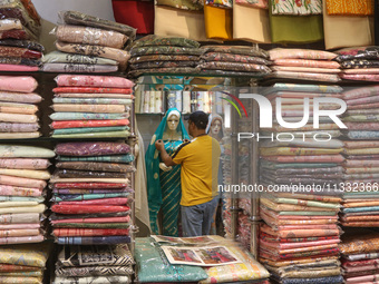 A man is adjusting a mannequin at a market ahead of the Eid al-Adha festival in Srinagar, India, on June 15, 2024. Eid al-Adha is the holies...