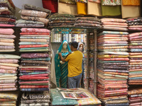 A man is adjusting a mannequin at a market ahead of the Eid al-Adha festival in Srinagar, India, on June 15, 2024. Eid al-Adha is the holies...