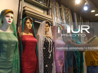 A man is adjusting a mannequin at a market ahead of the Eid al-Adha festival in Srinagar, India, on June 15, 2024. Eid al-Adha is the holies...