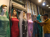 A man is adjusting a mannequin at a market ahead of the Eid al-Adha festival in Srinagar, India, on June 15, 2024. Eid al-Adha is the holies...