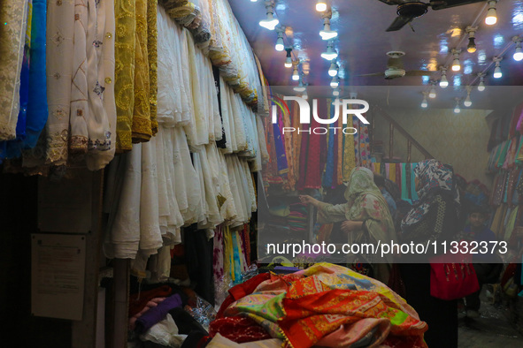 Women are shopping at a fabric store ahead of the Eid al-Adha festival in Srinagar, India, on June 15, 2024. Eid al-Adha is the holiest of t...