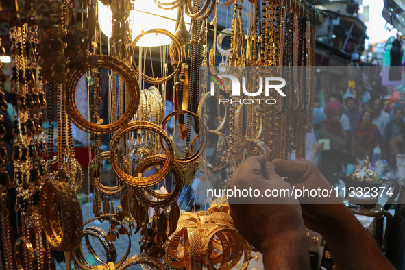 A man is arranging jewellery items at a market ahead of the Eid al-Adha festival in Srinagar, India, on June 15, 2024. Eid al-Adha is the ho...