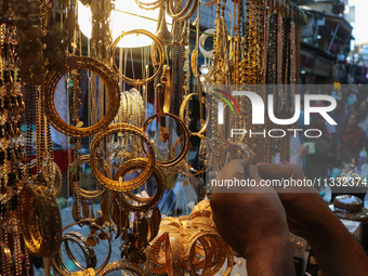 A man is arranging jewellery items at a market ahead of the Eid al-Adha festival in Srinagar, India, on June 15, 2024. Eid al-Adha is the ho...