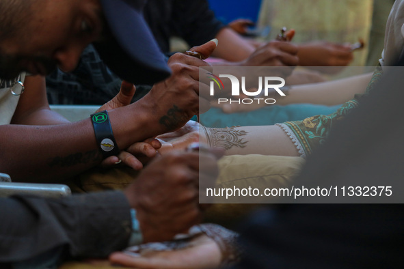 Indian artists are applying henna on the hands of Kashmiri Muslim girls ahead of the Eid al-Adha festival in Srinagar, India, on June 15, 20...