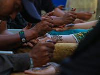 Indian artists are applying henna on the hands of Kashmiri Muslim girls ahead of the Eid al-Adha festival in Srinagar, India, on June 15, 20...