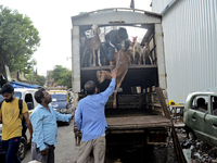 Goats are being taken out from a mini truck in a livestock market on the eve of the Muslim festival of Eid-al-Adha in Mumbai, India, on June...