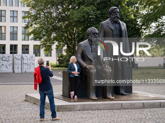 People are taking photos in front of the Marx and Engels monument in Berlin, Germany, on June 15, 2024. (