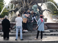 People are enjoying their time at Neptune Fountain in Berlin, Germany, on June 15, 2024. (