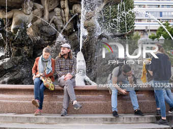 People are enjoying their time at Neptune Fountain in Berlin, Germany, on June 15, 2024. (