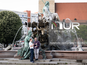 People are enjoying their time at Neptune Fountain in Berlin, Germany, on June 15, 2024. (