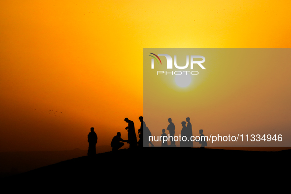 People are gathering to perform Eid prayers on one of the hills in the village of Abu Sir, in the middle of some of the ancient archaeologic...