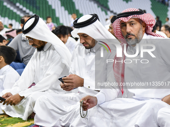 Muslim men are sitting before performing Eid al-Adha morning prayers at the Education City Stadium in Doha, Qatar, on June 16, 2024. Muslims...