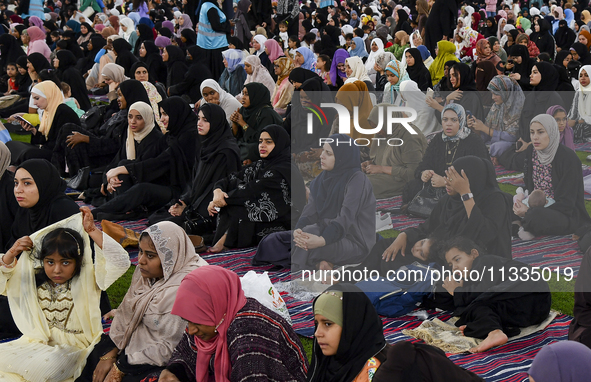 Muslim women are sitting before performing Eid al-Adha morning prayers at the Education City Stadium on the first day of the Eid al-Adha hol...