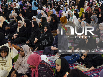 Muslim women are sitting before performing Eid al-Adha morning prayers at the Education City Stadium on the first day of the Eid al-Adha hol...