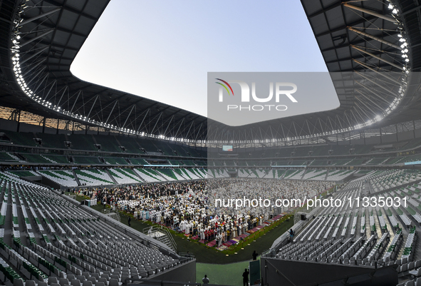 Worshipers are performing Eid al-Adha prayers at the Education City Stadium on the first day of the Eid al-Adha holiday in Doha, Qatar, on J...