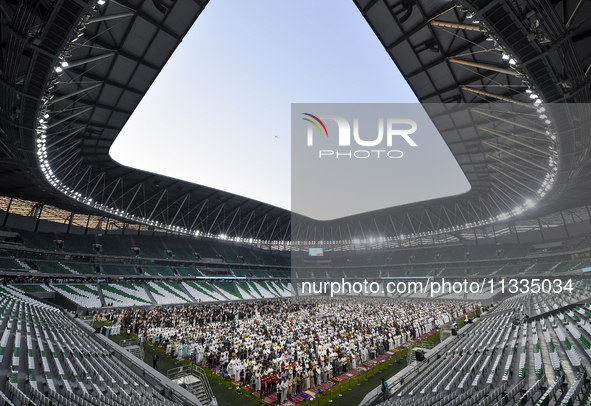 Worshipers are performing Eid al-Adha prayers at the Education City Stadium on the first day of the Eid al-Adha holiday in Doha, Qatar, on J...