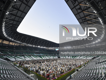 Worshipers are performing Eid al-Adha prayers at the Education City Stadium on the first day of the Eid al-Adha holiday in Doha, Qatar, on J...