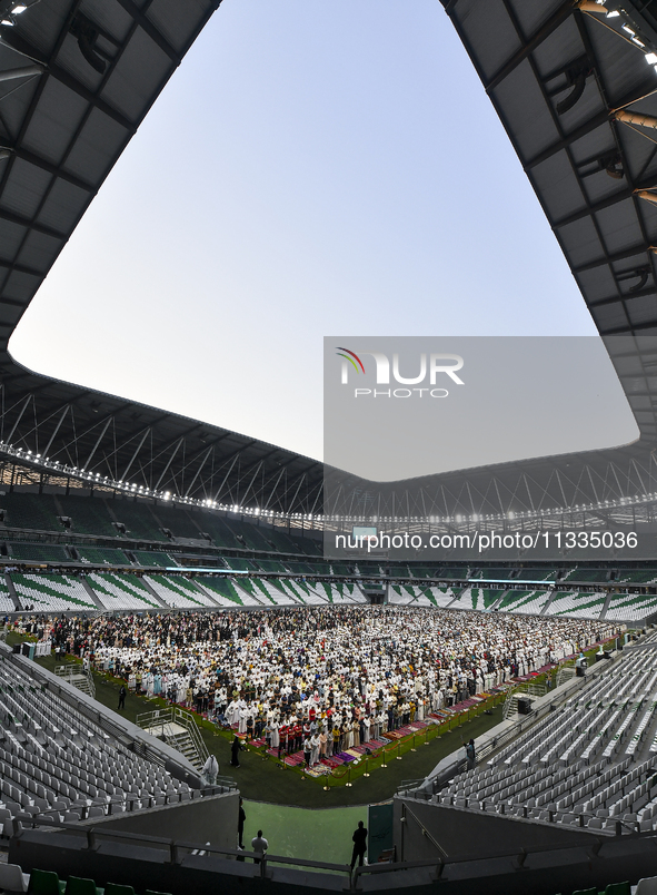 Worshipers are performing Eid al-Adha prayers at the Education City Stadium on the first day of the Eid al-Adha holiday in Doha, Qatar, on J...