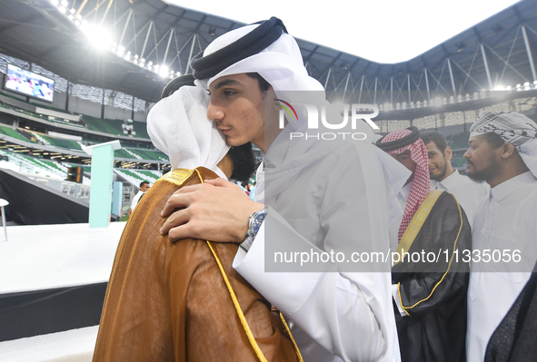 People are greeting each other after performing the Eid al-Adha morning prayer at the Education City Stadium on the first day of the Eid al-...