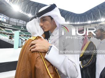 People are greeting each other after performing the Eid al-Adha morning prayer at the Education City Stadium on the first day of the Eid al-...