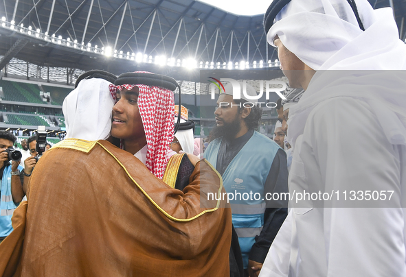 People are greeting each other after performing the Eid al-Adha morning prayer at the Education City Stadium on the first day of the Eid al-...