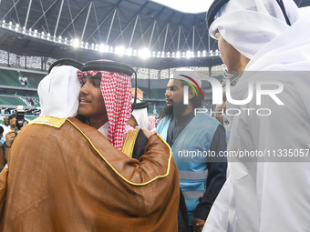 People are greeting each other after performing the Eid al-Adha morning prayer at the Education City Stadium on the first day of the Eid al-...