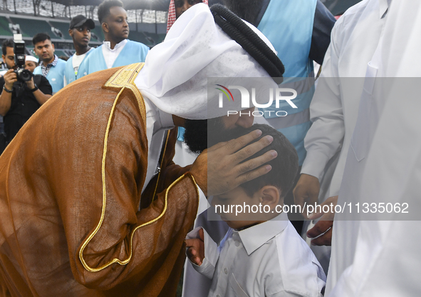 People are greeting each other after performing the Eid al-Adha morning prayer at the Education City Stadium on the first day of the Eid al-...