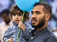 A boy is celebrating with a balloon after performing the Eid al-Adha morning prayer at the Education City Stadium on the first day of the Ei...