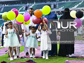 A girl is celebrating with balloons after performing the Eid al-Adha morning prayer at the Education City Stadium on the first day of the Ei...