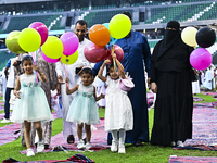 A girl is celebrating with balloons after performing the Eid al-Adha morning prayer at the Education City Stadium on the first day of the Ei...