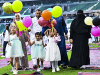 A girl is celebrating with balloons after performing the Eid al-Adha morning prayer at the Education City Stadium on the first day of the Ei...