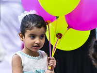 A girl is celebrating with balloons after performing the Eid al-Adha morning prayer at the Education City Stadium on the first day of the Ei...