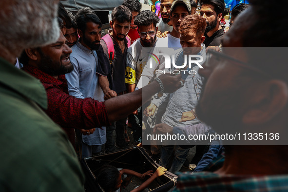 People are watching a magic show organized by non-Kashmiris from different states of India ahead of Eid-Ul-Adha in Sopore, Jammu and Kashmir...