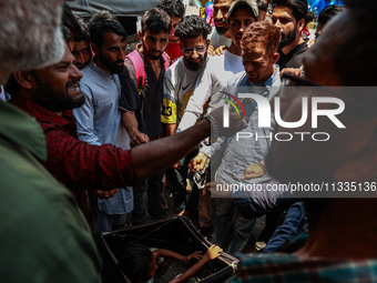 People are watching a magic show organized by non-Kashmiris from different states of India ahead of Eid-Ul-Adha in Sopore, Jammu and Kashmir...