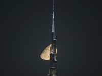 The Moon is appearing behind the world's tallest tower, Burj Khalifa, in Dubai, UAE, on June 16, 2024. (