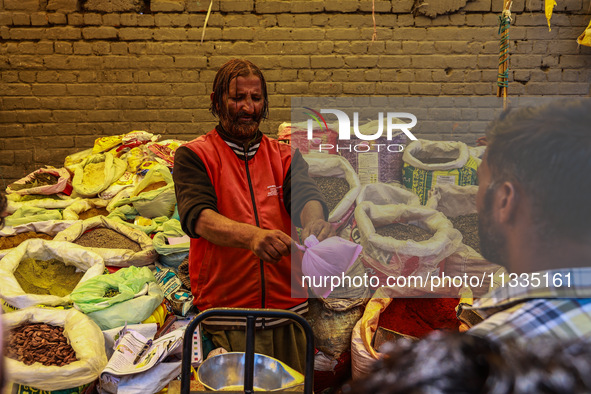 A vendor is selling spices to customers ahead of Eid-Ul-Acha in Sopore, Jammu and Kashmir, India, on June 16, 2024 