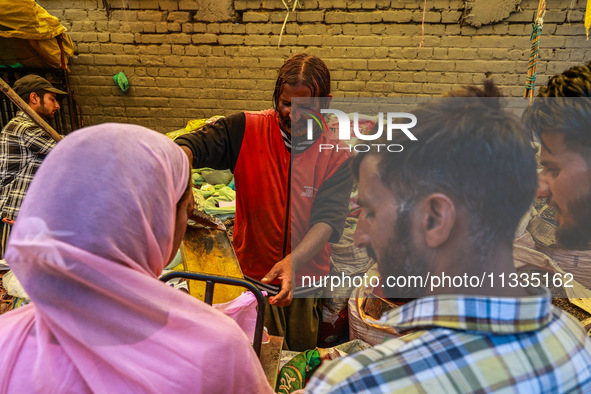 A vendor is selling spices to customers ahead of Eid-Ul-Acha in Sopore, Jammu and Kashmir, India, on June 16, 2024 