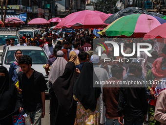 People are walking as they shop for Eid-Ul-Adha in Sopore, Jammu and Kashmir, India, on June 16, 2024. (