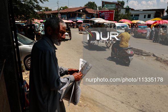 A man is reading a newspaper on a hot summer day in Sopore, Jammu and Kashmir, India, on June 16, 2024. 