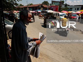 A man is reading a newspaper on a hot summer day in Sopore, Jammu and Kashmir, India, on June 16, 2024. (