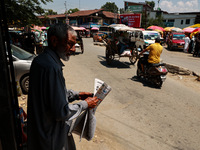 A man is reading a newspaper on a hot summer day in Sopore, Jammu and Kashmir, India, on June 16, 2024. (