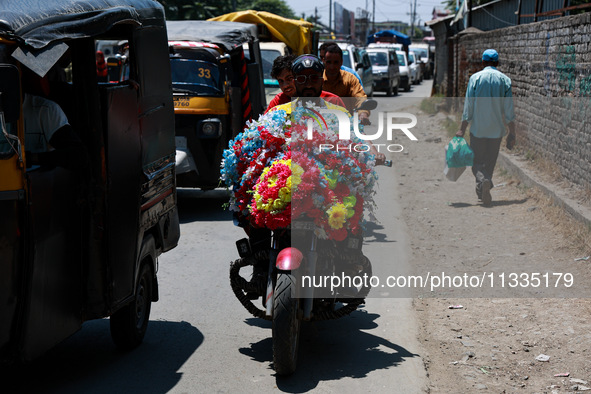 A biker is moving with garlands put on a bike in Sopore, Jammu and Kashmir, India, on June 16, 2024. 