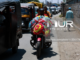 A biker is moving with garlands put on a bike in Sopore, Jammu and Kashmir, India, on June 16, 2024. (