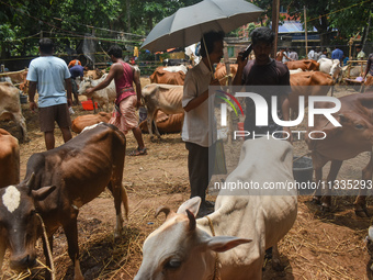 People are buying sacrificial animals from a cattle market on a hot summer day, ahead of Eid al-Adha celebrations on the outskirts of Kolkat...