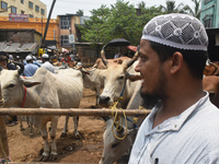 People are buying sacrificial animals from a cattle market on a hot summer day, ahead of Eid al-Adha celebrations on the outskirts of Kolkat...